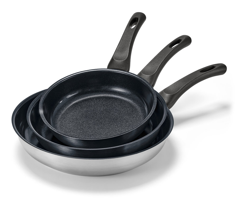 Három különböző méretű, kerámia bevonatú nemesacél serpenyő egymásra helyezve.