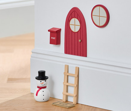 Manóajtó készlet egy falon egy hóemberrel és egy zsámollyal.