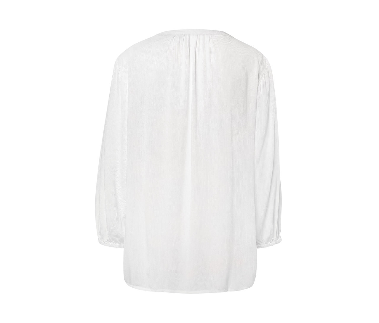 Egy fehér tunikablúz részlete.