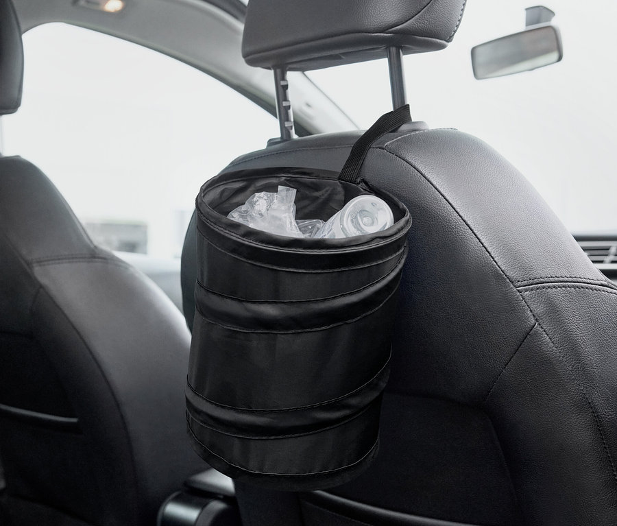 Egy fekete, összecsukható szemetes lóg egy autóülés hátulján.