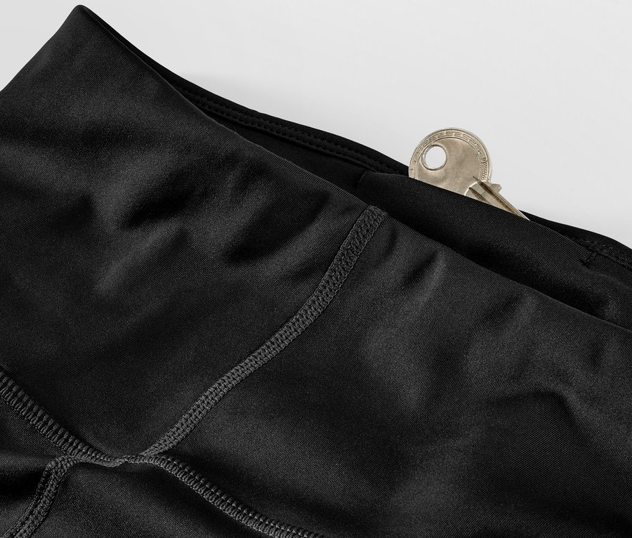 Egy fekete női sportnadrág részlete, kulcs van a zsebében.