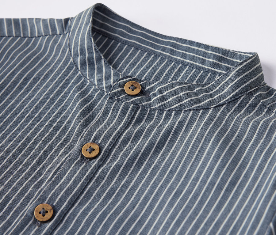 Egy csíkos, fa gombokkal ellátott gyereking részlete.