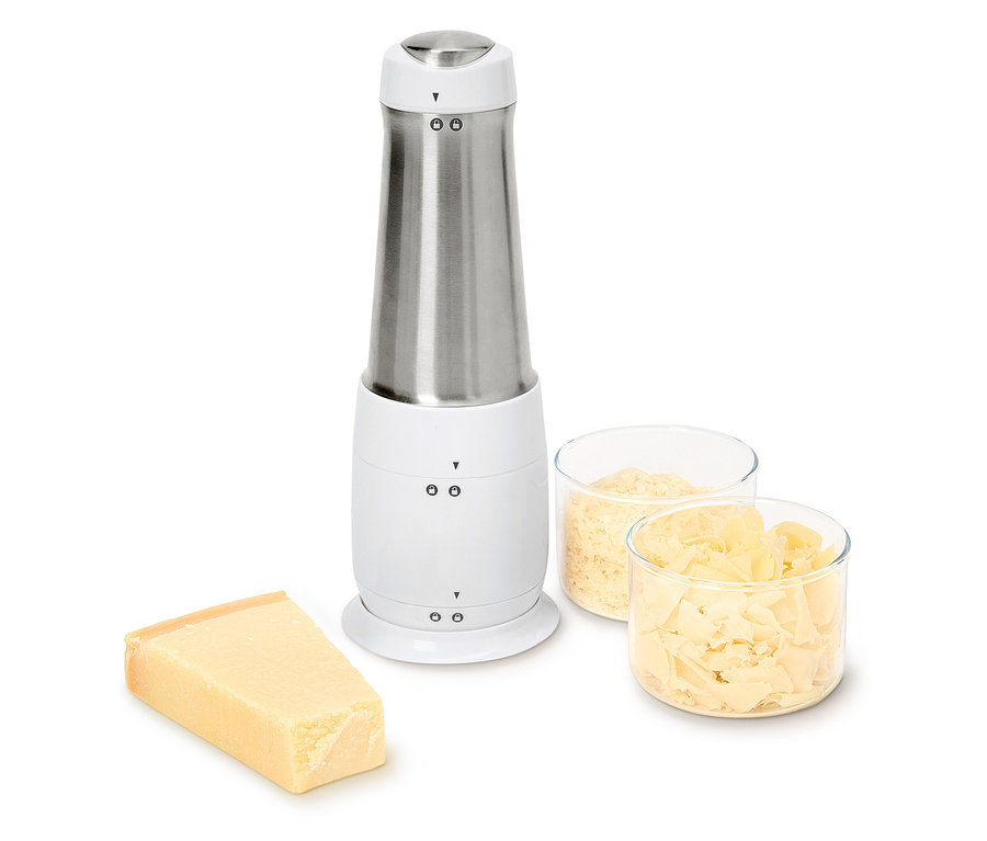 Elektromos sajtreszelő egy darab sajttal és két tál reszelt sajttal.
