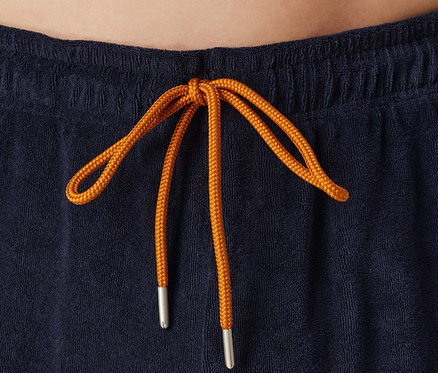 Kék rövidnadrág részlete narancssárga húzózsinórral.