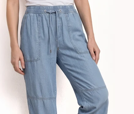 Egy személy világoskék farmerből készült, húzózsinóros és zsebes Street One »Bonny« joggpants-et visel.