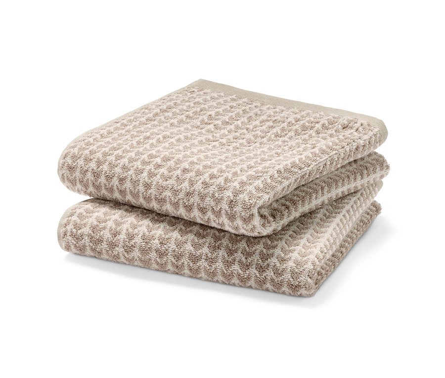 Egymásra helyezett bézs színű, 2 darabos prémium törölköző szett.