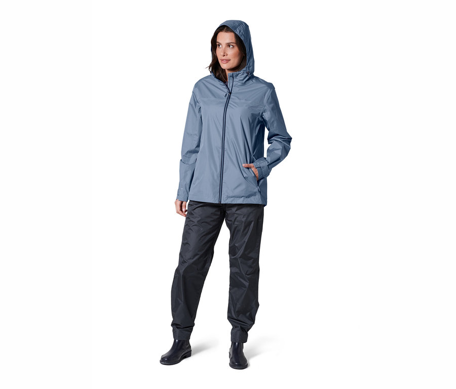 Nő pózol kék unisex esőkabátban.