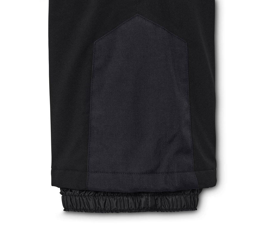 Egy fekete, magas derekú sínadrág részlete.