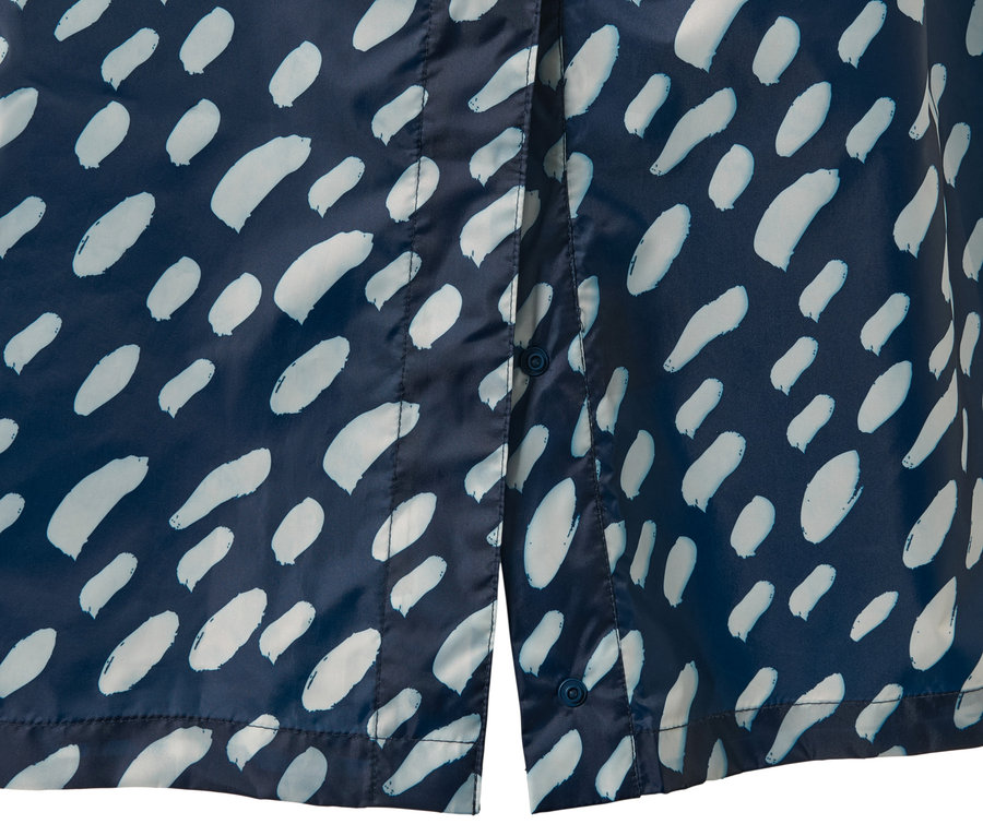 Egy sötétkék, mintás női poncsó esőkabát részlete.