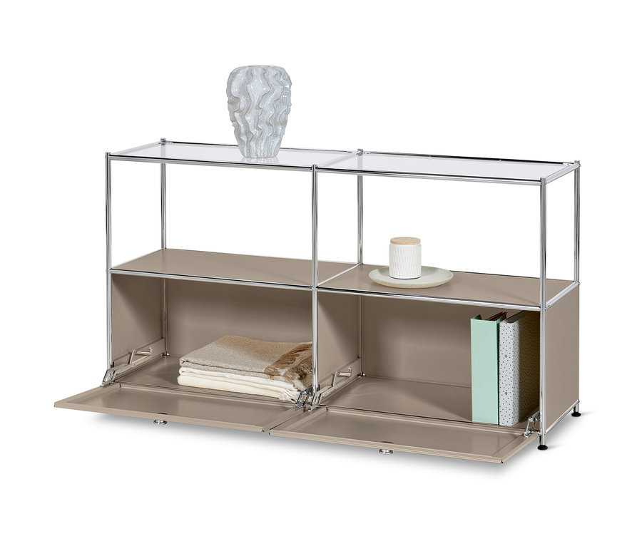 Szürkésbarna »CN3« fém komód 2 lenyíló ajtóval és üvegpolcokkal. A felső polcon egy váza, az alsó polcokon takarók és könyvek.