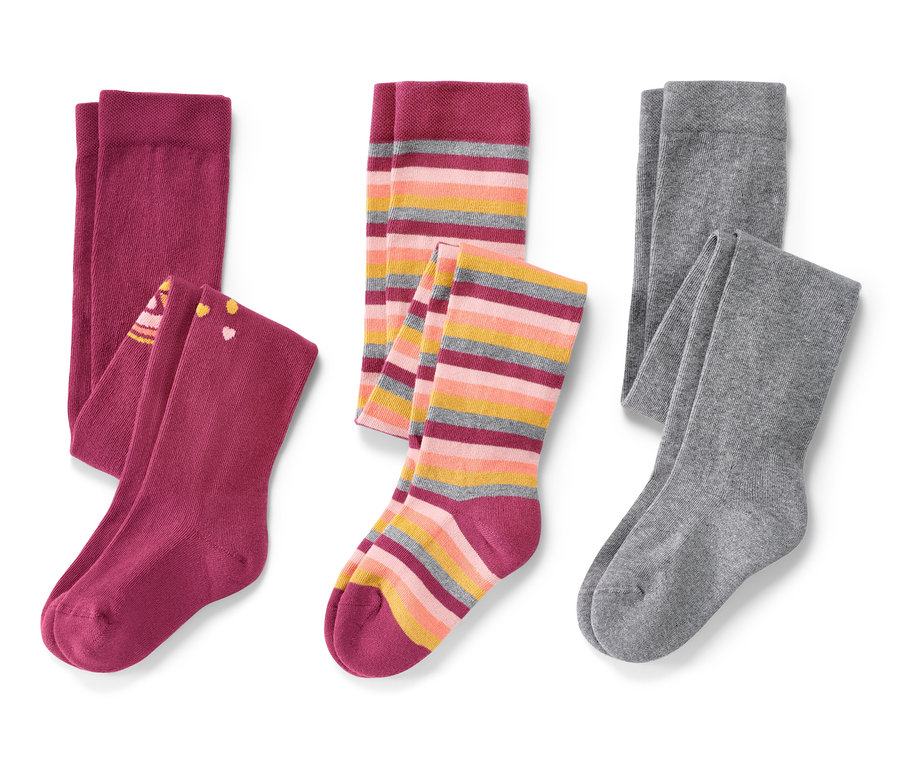 Három pár rózsaszín gyerek harisnyanadrág fehér háttérrel.