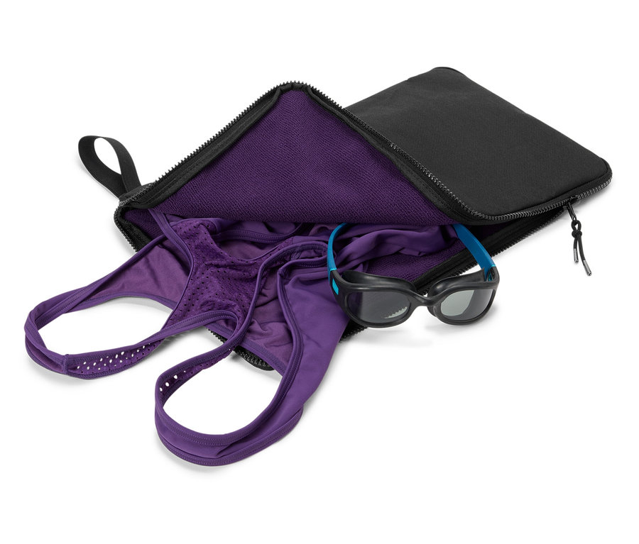 Lila fürdőruha és úszószemüveg egy fekete táskában.