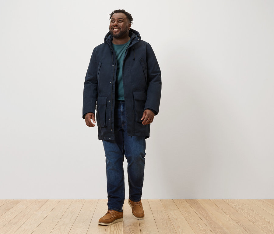 Férfi sétál, sötétkék parka kabátot visel.