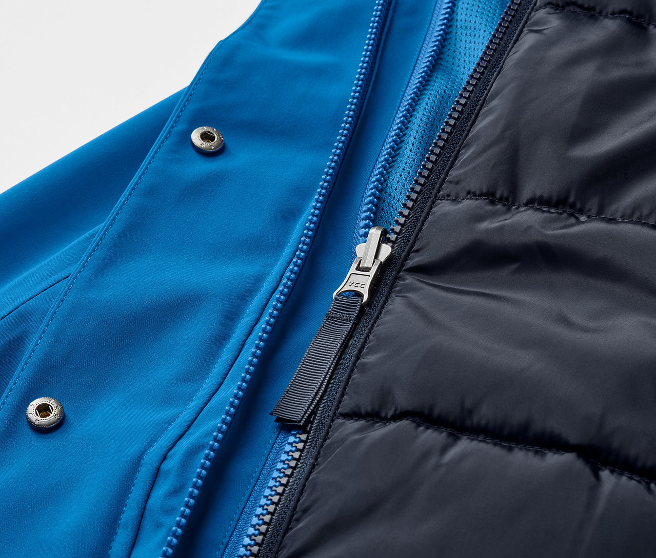 Egy kék, 3 az 1-ben funkcionális kabát részlete cipzárral.