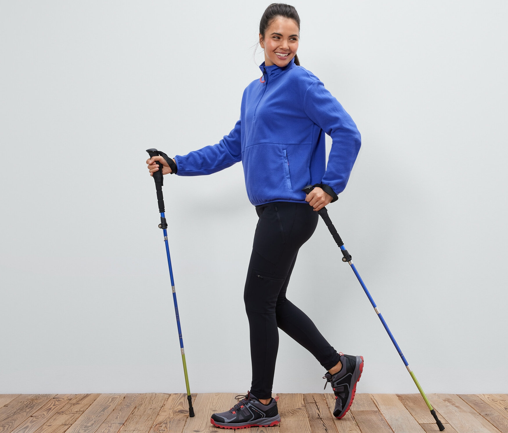 Nő használ egy pár túrabotot.