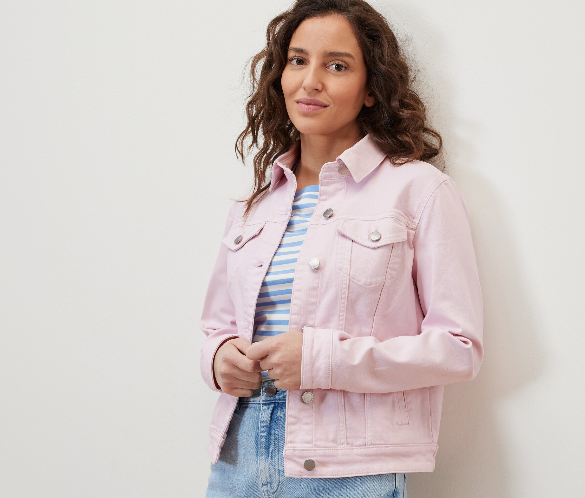 Nő farmerdzsekit és csíkos pólót visel.