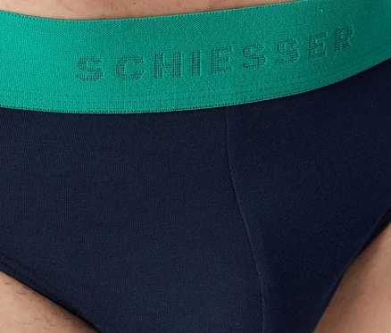 Tengerészkék férfi alsónadrág közelképe zöld derékpánttal, „SCHIESSER” felirattal.