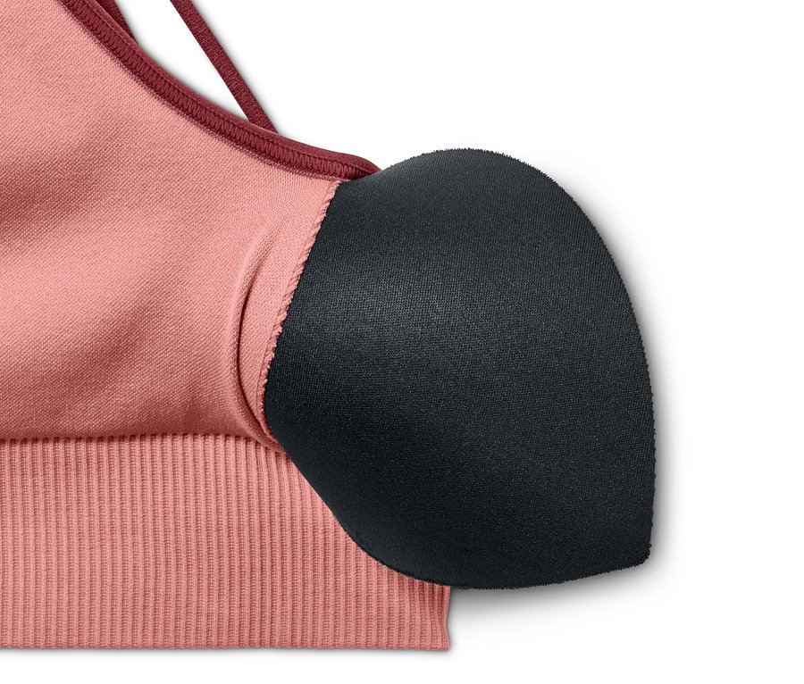 Egy rózsaszín női seamless sportmelltartó részlete.