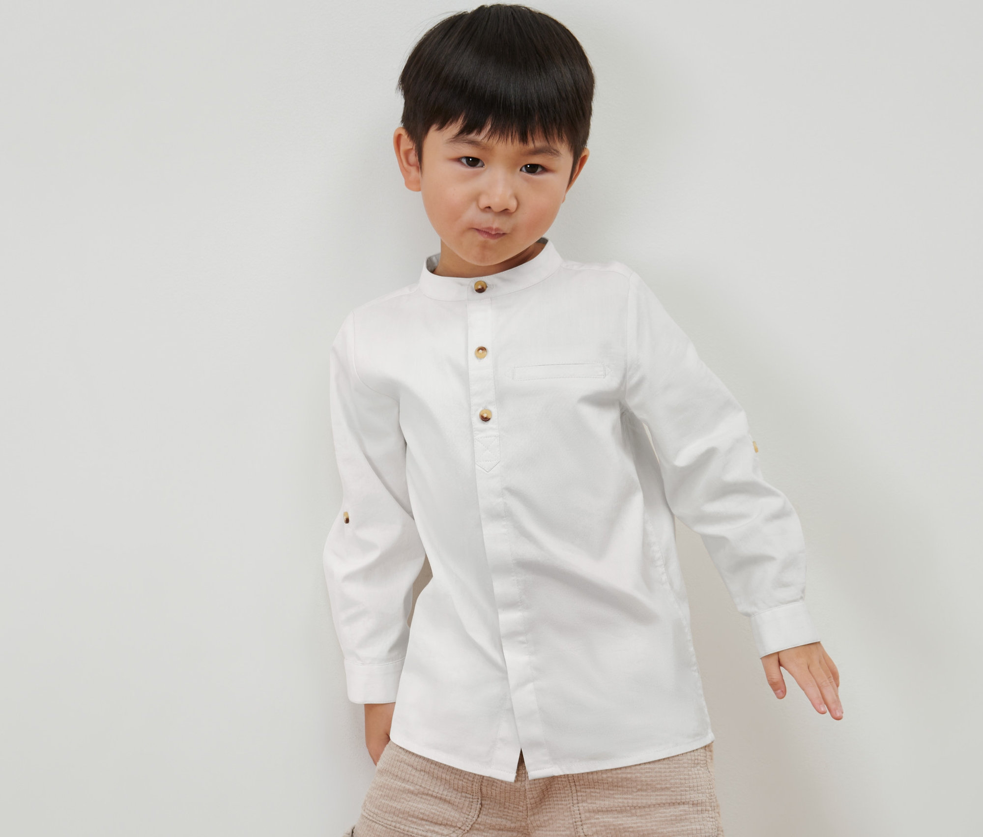 Fiúgyermek pózol kisfiú oxford ingben, fehér.