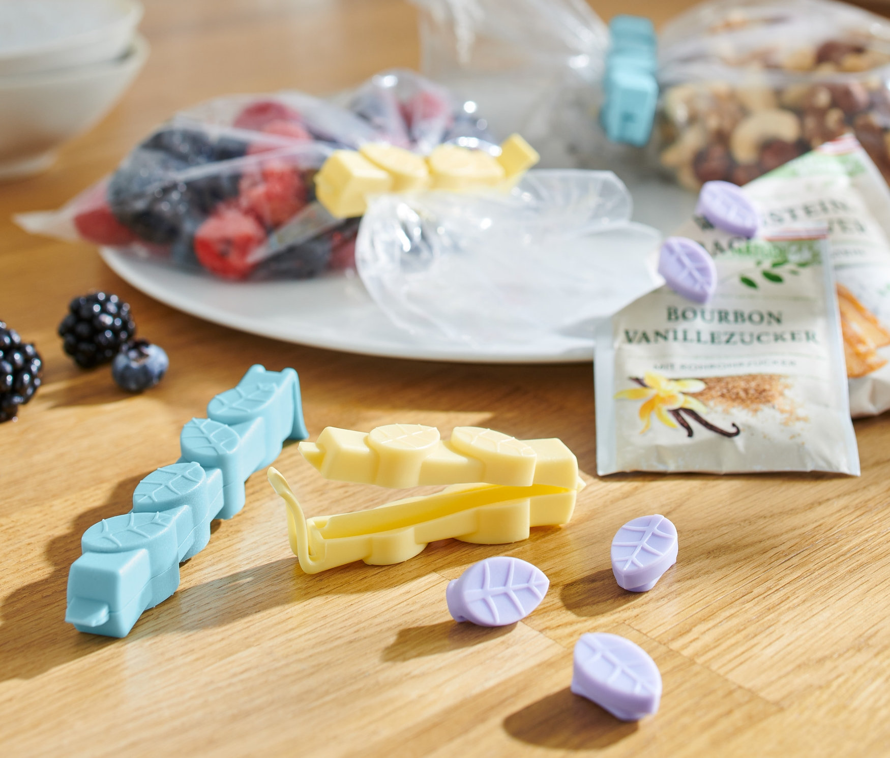 Az asztalon 15 aromazáró csipesz található, amelyek gyümölcsöt és diót tartalmazó zacskókat zárnak le.