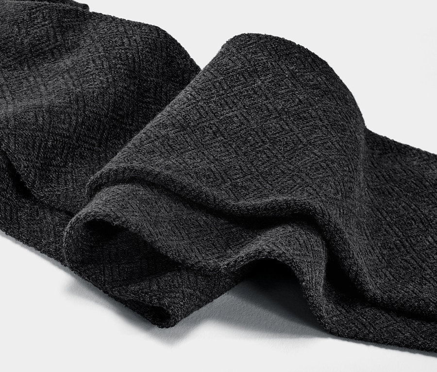 Közeli kép egy antracit színű, texturált harisnyáról.