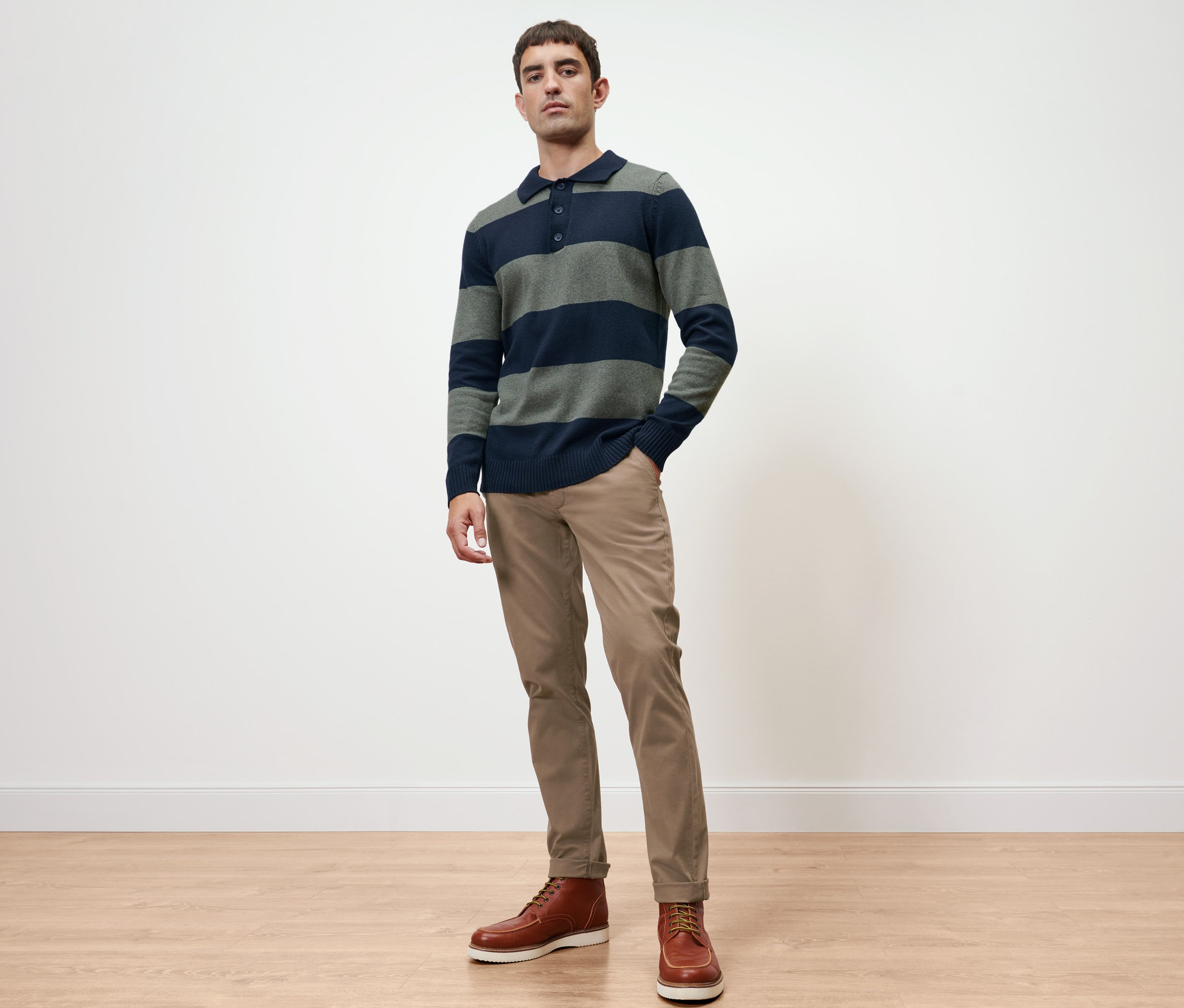 Férfi pulóverben és homokszínű chinóban pózol.