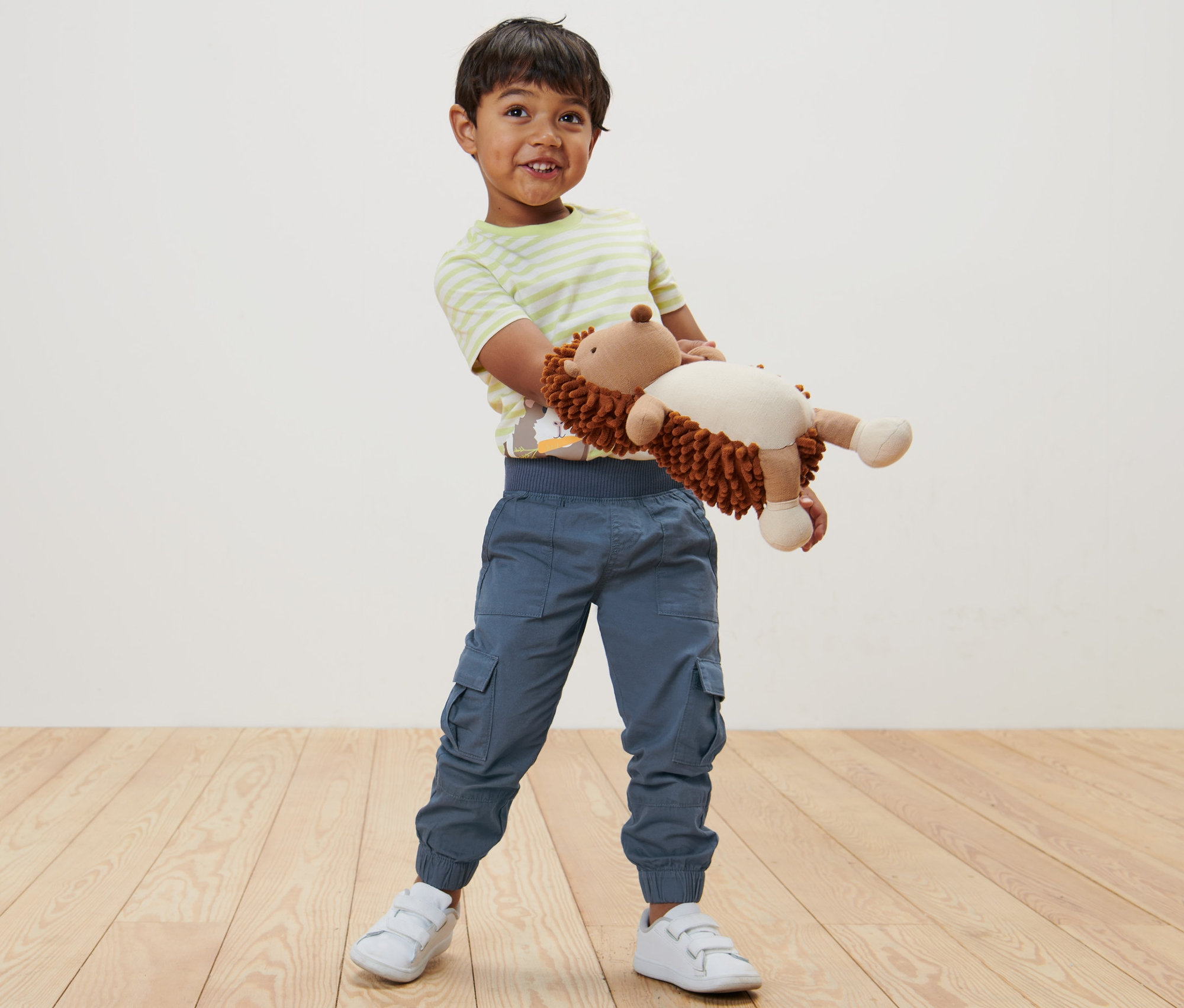 Fiú plüss sünit tart, Kinder-Pull-on-Pants – Fit »Anton« és fehér tornacipőt visel.