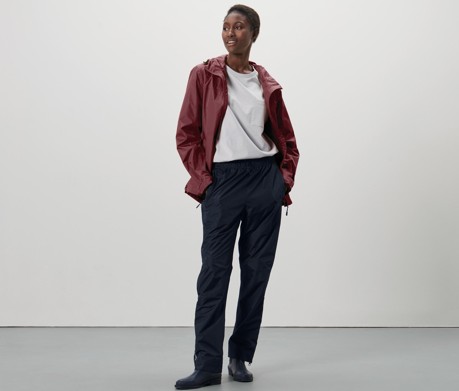 Nő áll és high-tech esőnadrágot visel.