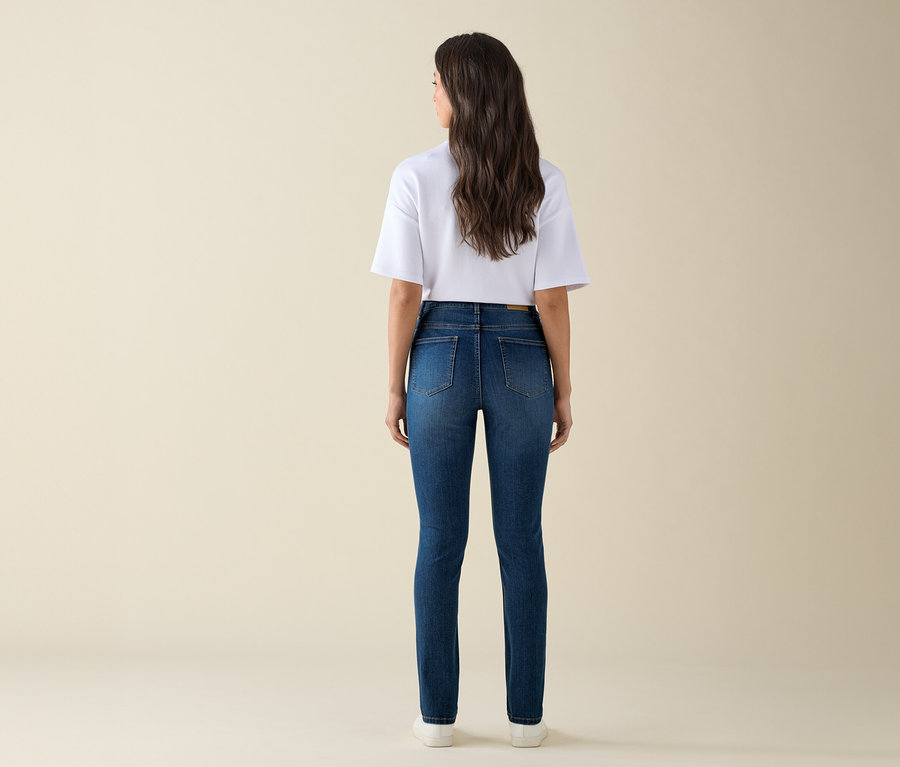 Hátulról álló nő, aki egy kék farmer slim fit »Emma« farmert és egy fehér pólót visel.