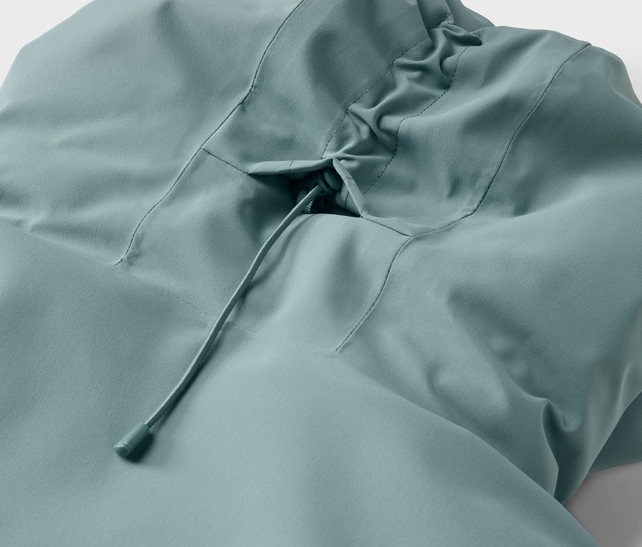 Világoskék kapucnis kabát részlete zsinórral.