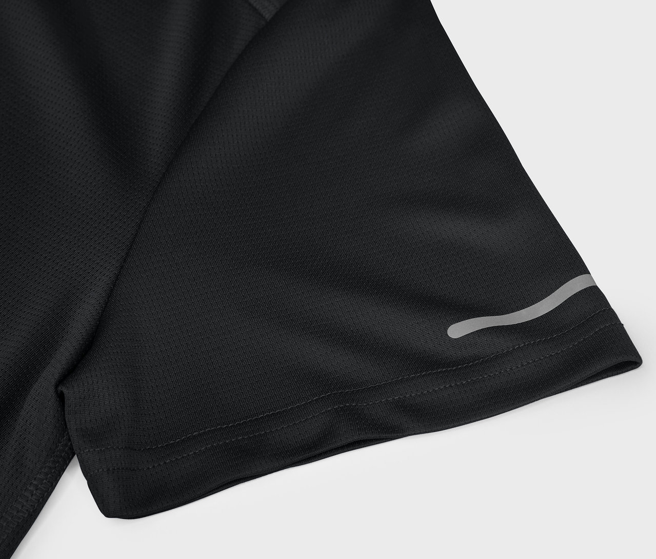 Egy fekete, rövid ujjú sportpóló részlete fényvisszaverő elemmel.