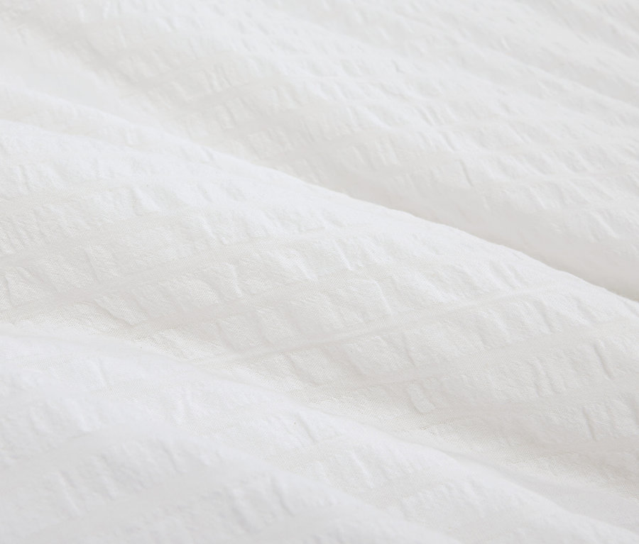 Egy texturált fehér anyag közeli képe.