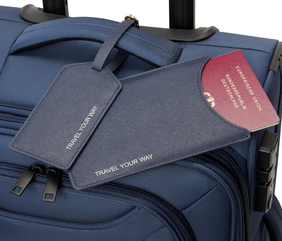 Kék gurulós bőrönd útlevéltartóval és poggyászcímkével.