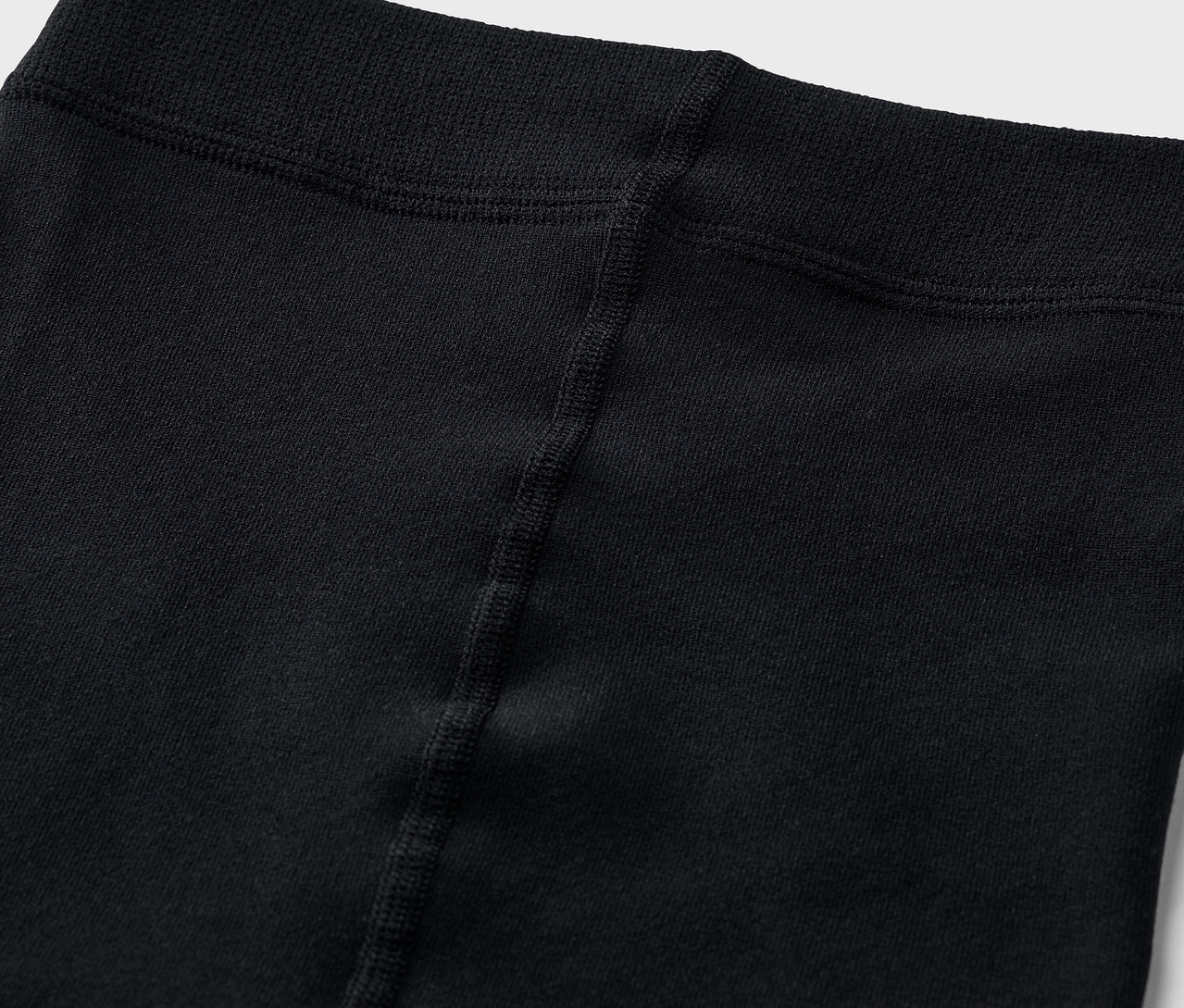 Egy fekete leggings derékrészének közeli felvétele.