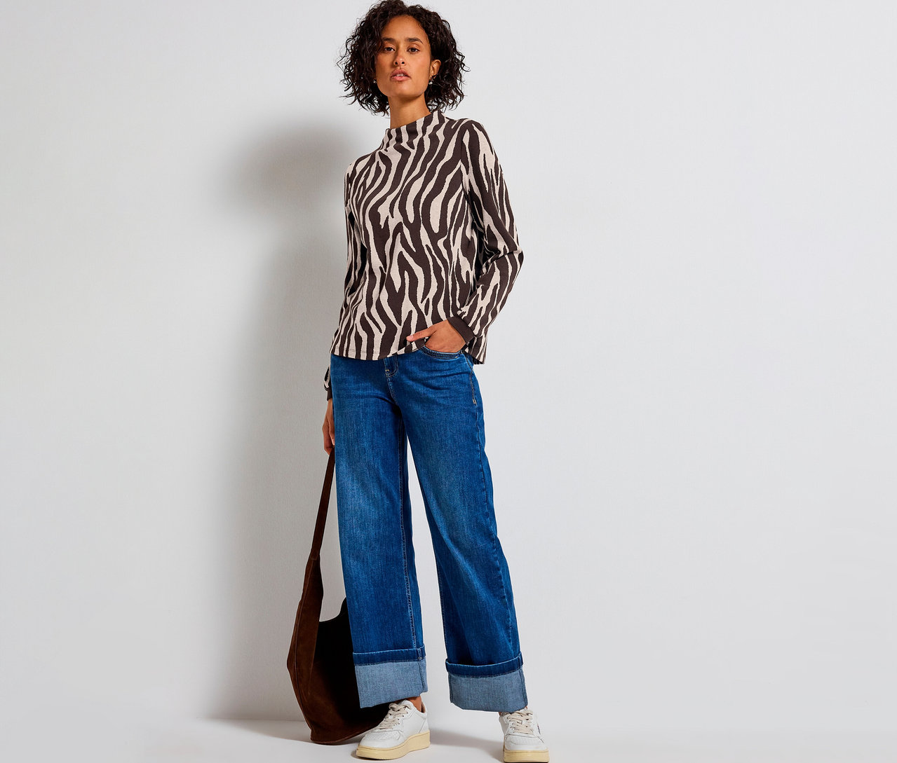 Nő Street One zebra mintás jacquard pólóban, farmerben és táskával.