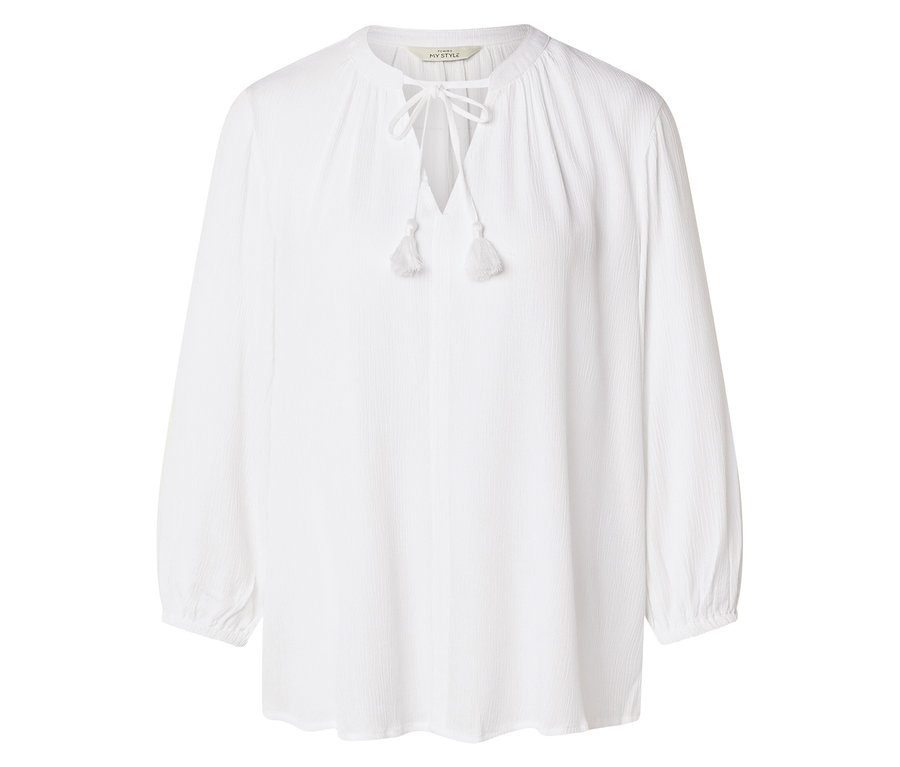 Egy fehér, hosszú ujjú ing zsinórral és bojtokkal látható fehér háttér előtt.