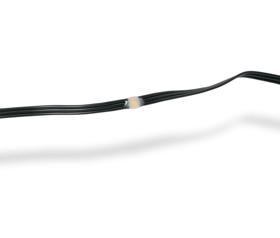 Egy fekete fényfüzér közeli képe egyetlen áttetsző fehér LED-fénnyel.