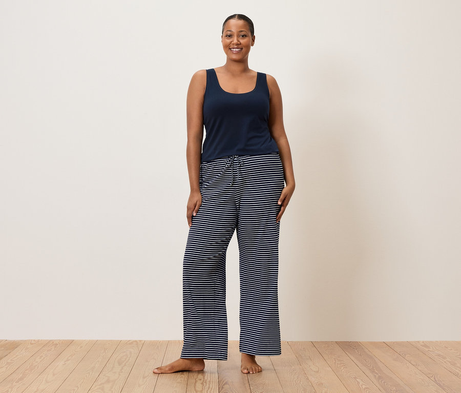 Nő kék trikót és csíkos nadrágot visel.