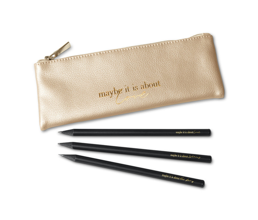 Egy arany színű, cipzáras tolltartó fekszik három feliratos fekete ceruza mellett.