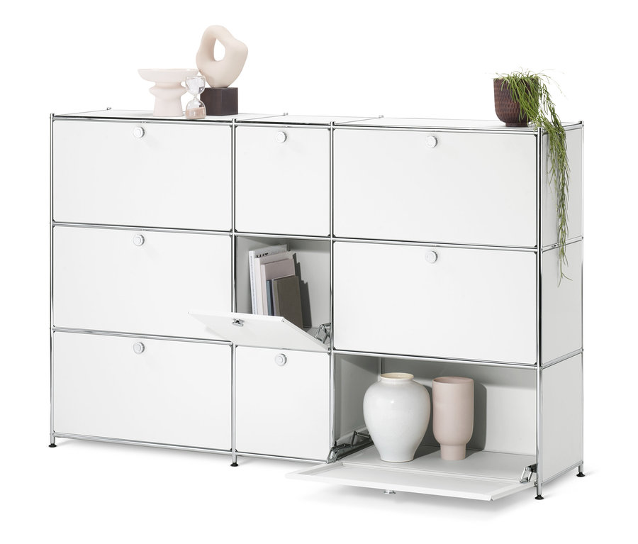 Fehér »CN3« komód 9 ajtóval, melyből az egyik nyitva van, benne könyvekkel és dekorációval.