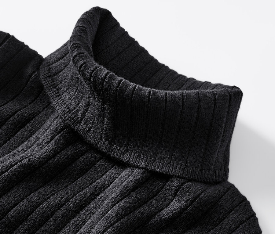 Egy fekete, bordás kötésű garbó részletfotója.