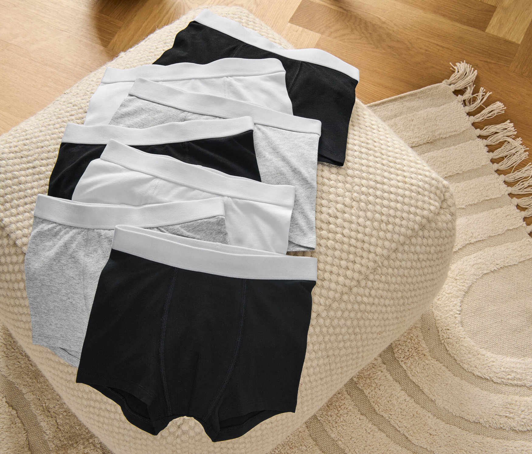 7 darab szürke/fehér/fekete gyerek boxeralsó egy puffon.