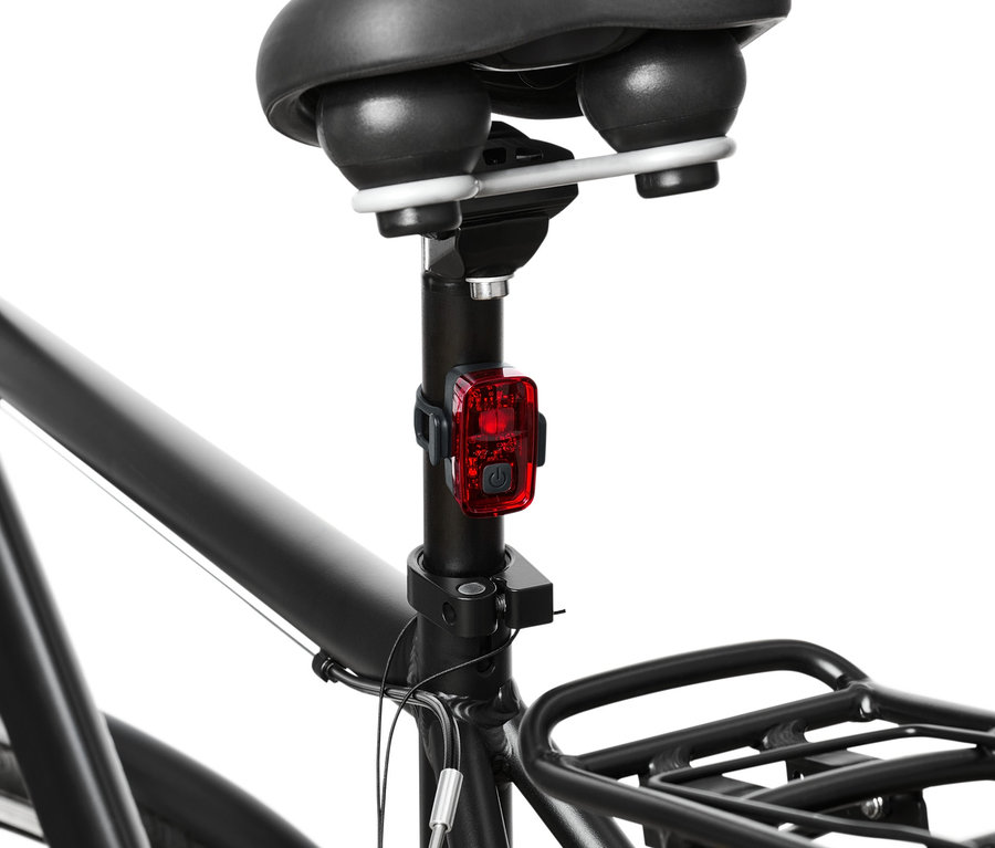 Egy kerékpár hátsó részletének képe, a kerékpár világításszett piros lámpájával.