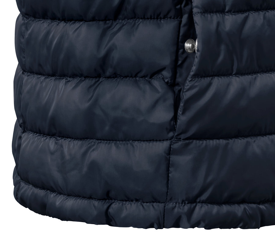 A sötétkék/barna női kifordítható steppelt mellény részlete.