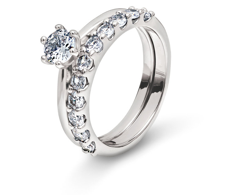 Két ezüst gyűrű átlátszó kövekkel fehér háttéren.