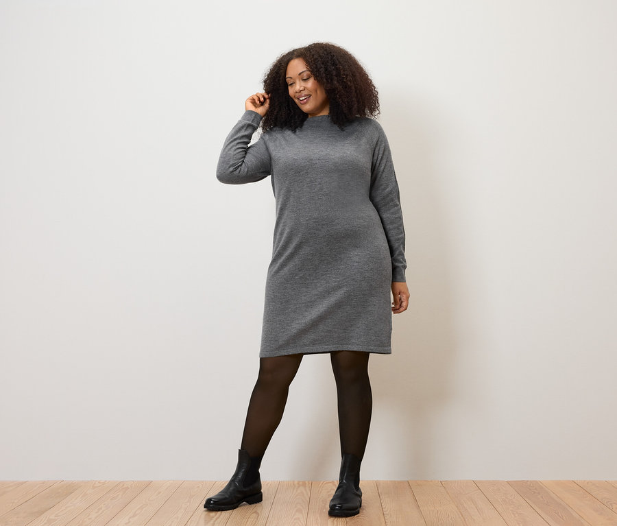 Nő pózol kötött ruhában.