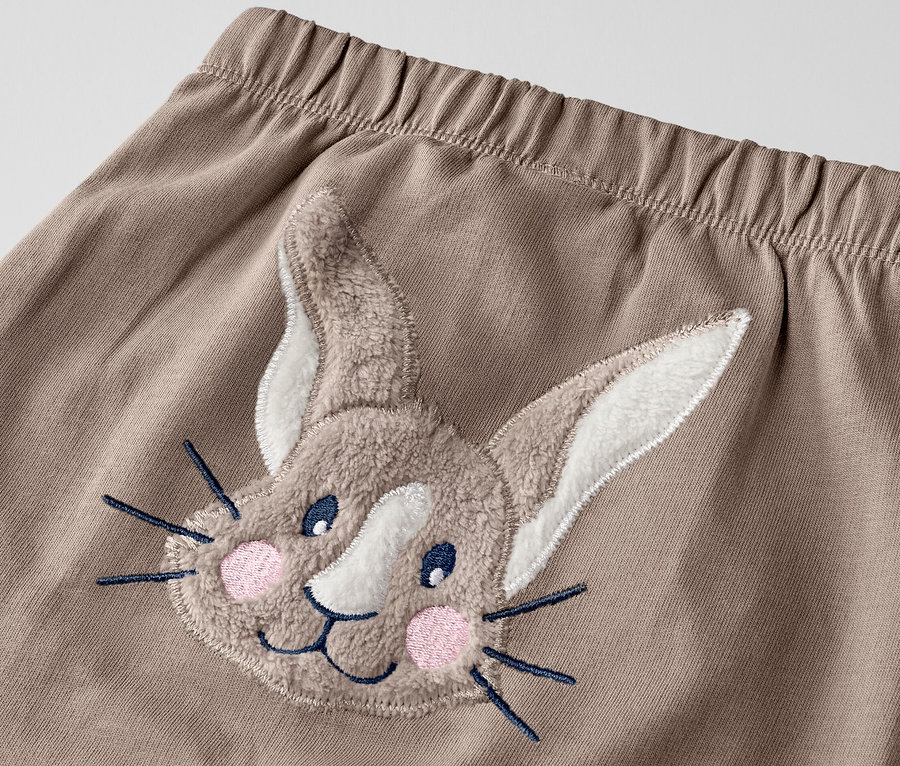 Egy nyuszis kisgyerek szabadidőnadrág részlete.