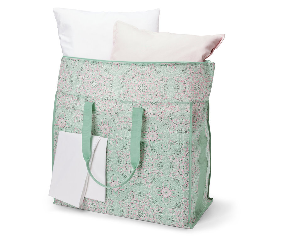 Egy jumbo ágyneműtartó táska fehér és rózsaszín párnákkal.