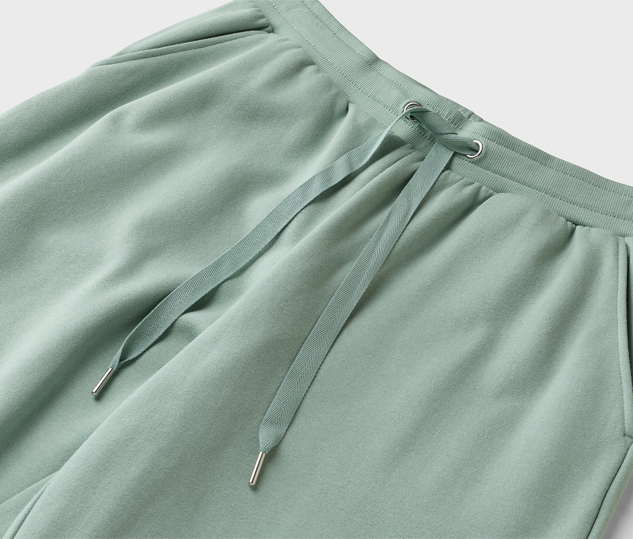 Egy világoszöld színű, húzózsinóros jogging alsó közeli képe.