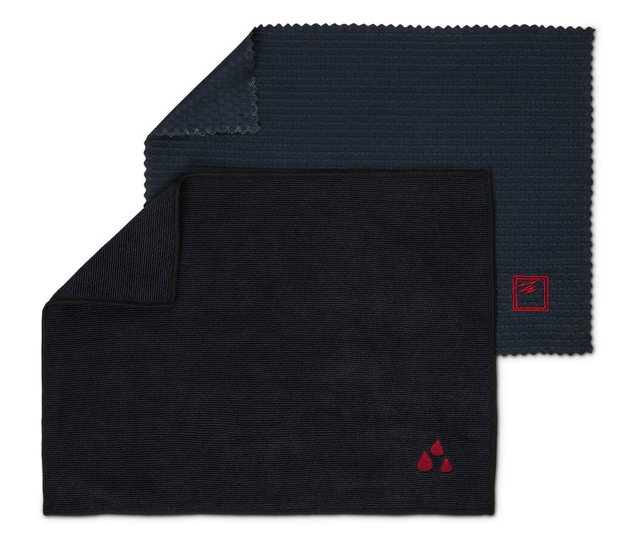 Két sötét tisztítókendő, az egyik piros logóval, három csepp formájában, a másik pedig piros logóval, egy négyzetben.